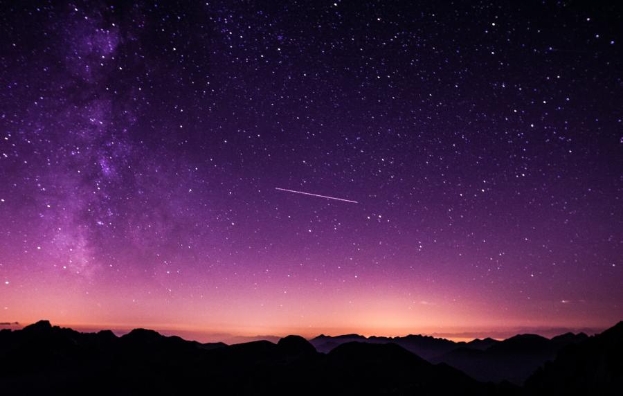 Purple night sky over a horizon dotted with stars.